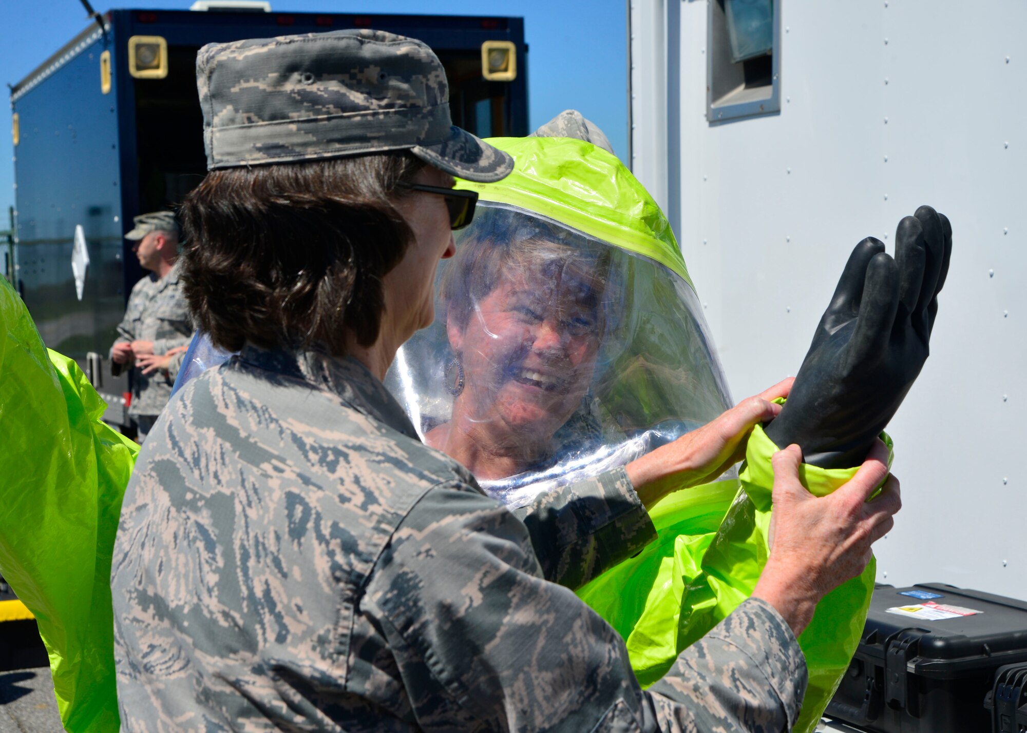 Col. Lisa Pike, 436th Mission Support Group commander, helps Tracy Skrobot, 436th Medical Group honorary commander, don a hazardous material suit while touring the 436th MSG April 20, 2016, at Dover Air Force Base, Del. These suits are worn by Dover AFB firefighters when responding to events with hazardous materials. (U.S. Air Force photo/Senior Airman William Johnson)