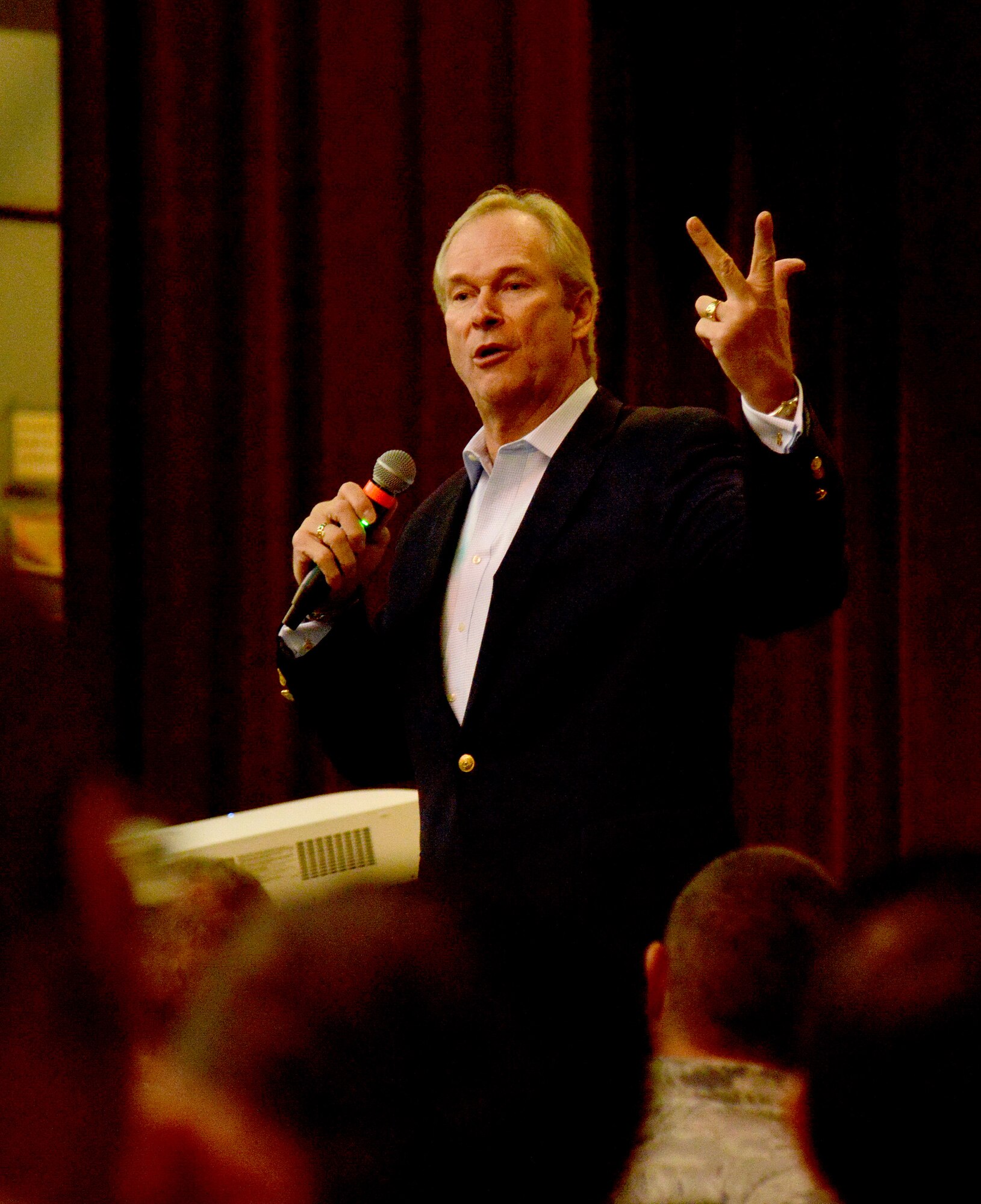 Motivational speaker Dan Clark speaks to Airmen at the Kirtland Base Theater April 19. Clark said his two week tour of bases in Iraq in 2005 solidified his commitment to serving the military at home and abroad. He aims to change behaviors by sharing a message of reinvigorating passion in purpose, building strong connections in the workplace, and transforming the workforce into high performance thinkers. Col. Eric Froehlich, commander of the 377th Air Base Wing, had the opportunity to hear Clark speak in 2013 at Shepherd Air Force Base, Texas, and found his message to be inspiring. He knew it the message would be of great benefit to the men and women of Kirtland. (Photo by Jamie Burnett)