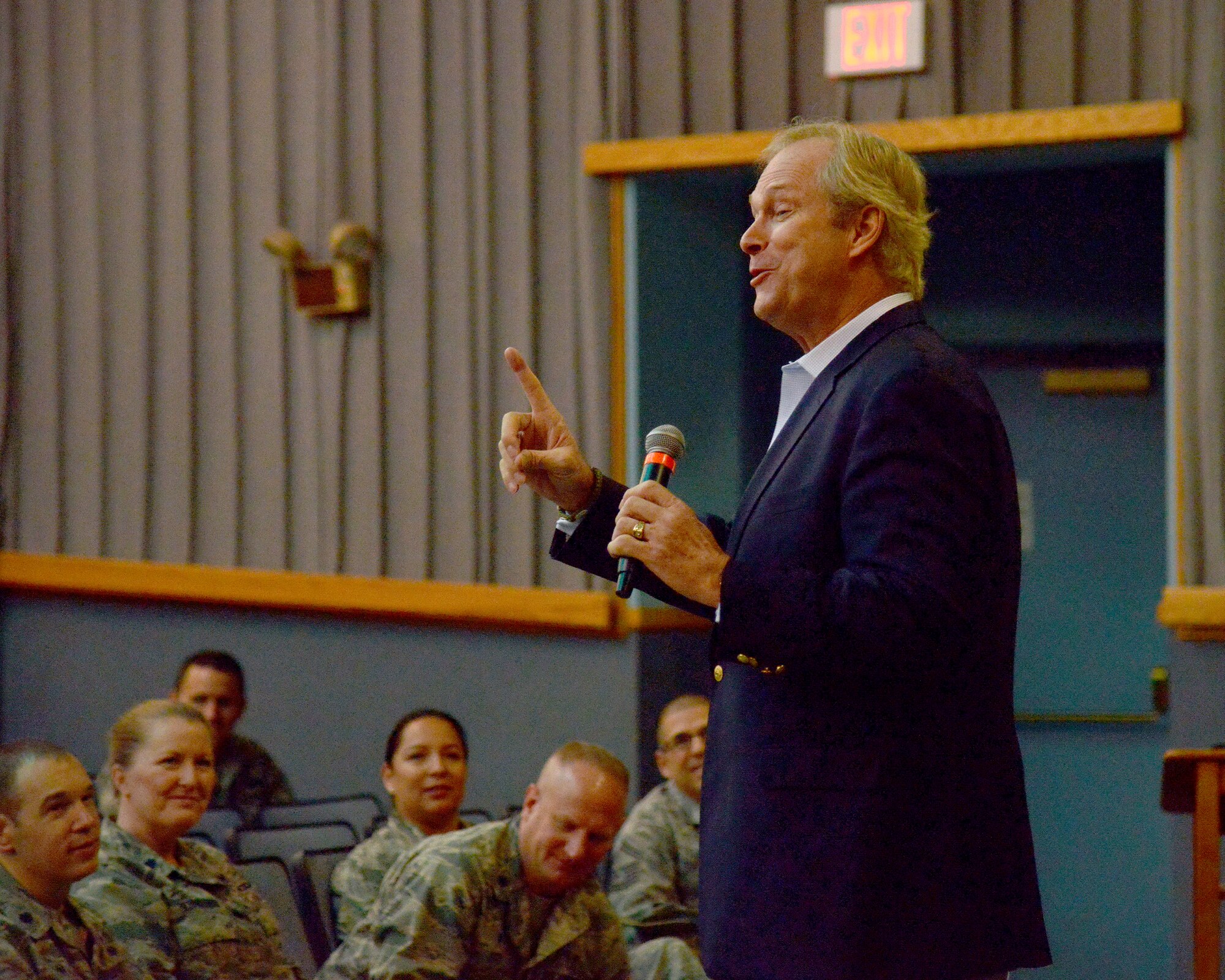 Motivational speaker Dan Clark speaks to Airmen at the Kirtland Base Theater April 19. Clark said his two week tour of bases in Iraq in 2005 solidified his commitment to serving the military at home and abroad. He aims to change behaviors by sharing a message of reinvigorating passion in purpose, building strong connections in the workplace, and transforming the workforce into high performance thinkers. Col. Eric Froehlich, commander of the 377th Air Base Wing, had the opportunity to hear Clark speak in 2013 at Shepherd Air Force Base, Texas, and found his message to be inspiring. He knew it the message would be of great benefit to the men and women of Kirtland. (Photo by Jamie Burnett)