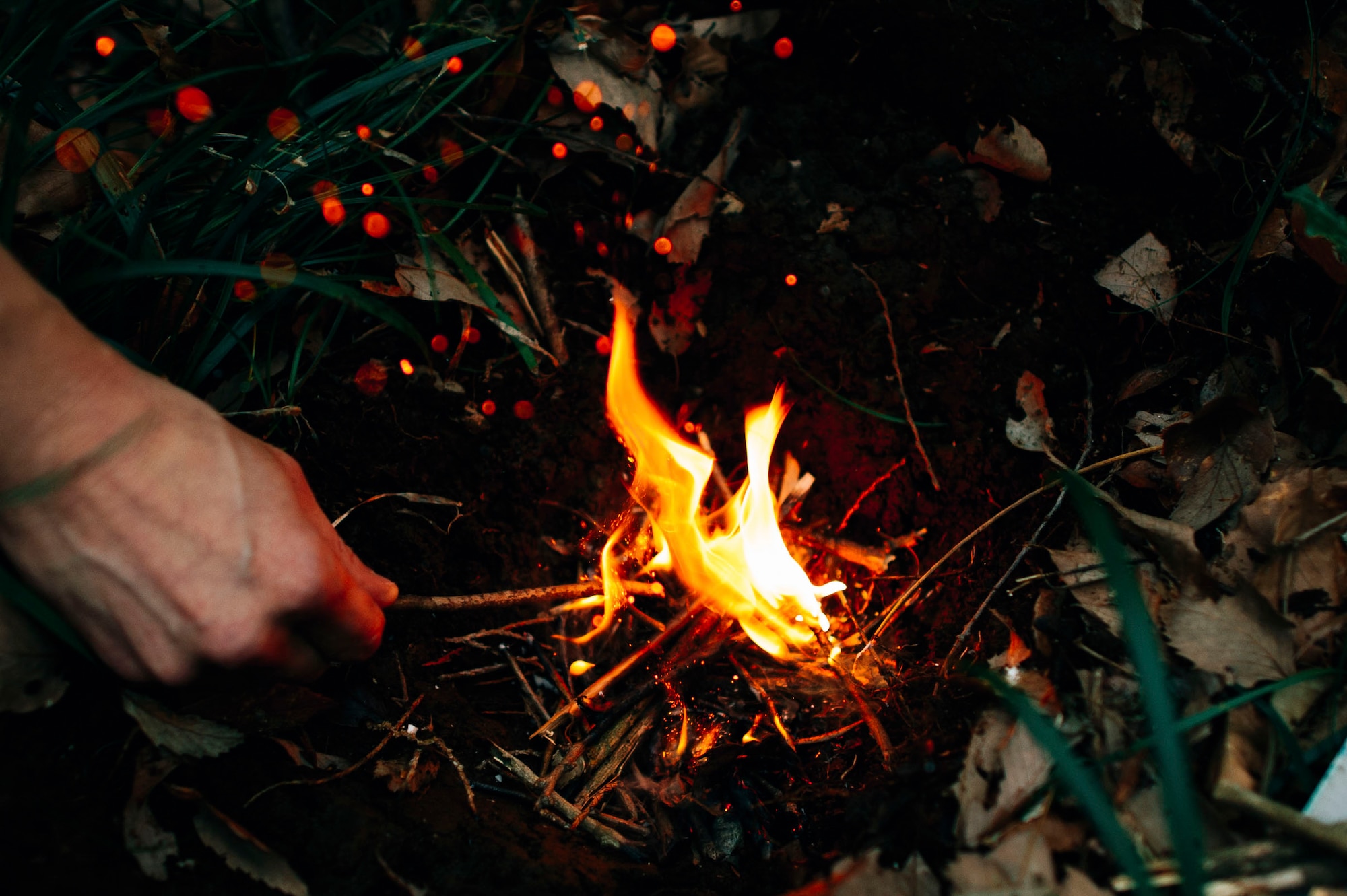 Staff Sgt. Justin Bender, 374th Operations Support Squadron Survival, Evasion, Resistance and Escape specialist, builds a fire in a fire pit at Tama Hills Recreation Area, Japan, April 21, 2016. Pilots must successfully complete survival, evasion, resistance and escape refresher training every three years to stay current with an array of survival skills. (U.S. Air Force photo by Senior Airman Delano Scott/Released)