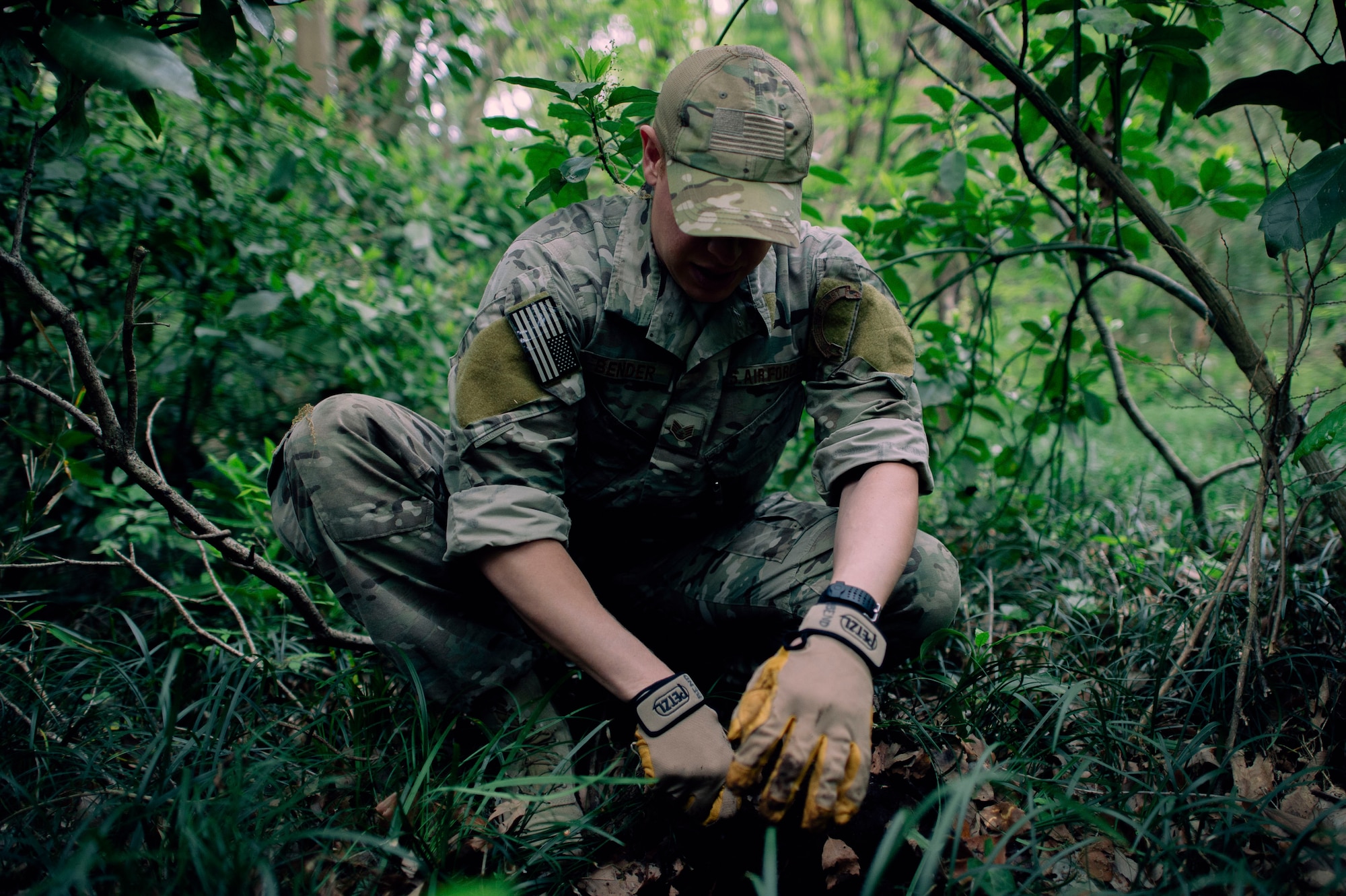 Staff Sgt. Justin Bender, 374th Operations Support Squadron Survival, Evasion, Resistance and Escape specialist, demonstrates survival techniques in the combat survival course at Tama Hills Recreation Area, Japan, April 21, 2016. The SERE specialists are trained in all major climatic conditions including arctic, desert, tropical, ocean and temperate. (U.S. Air Force photo by Senior Airman Delano Scott/Released)