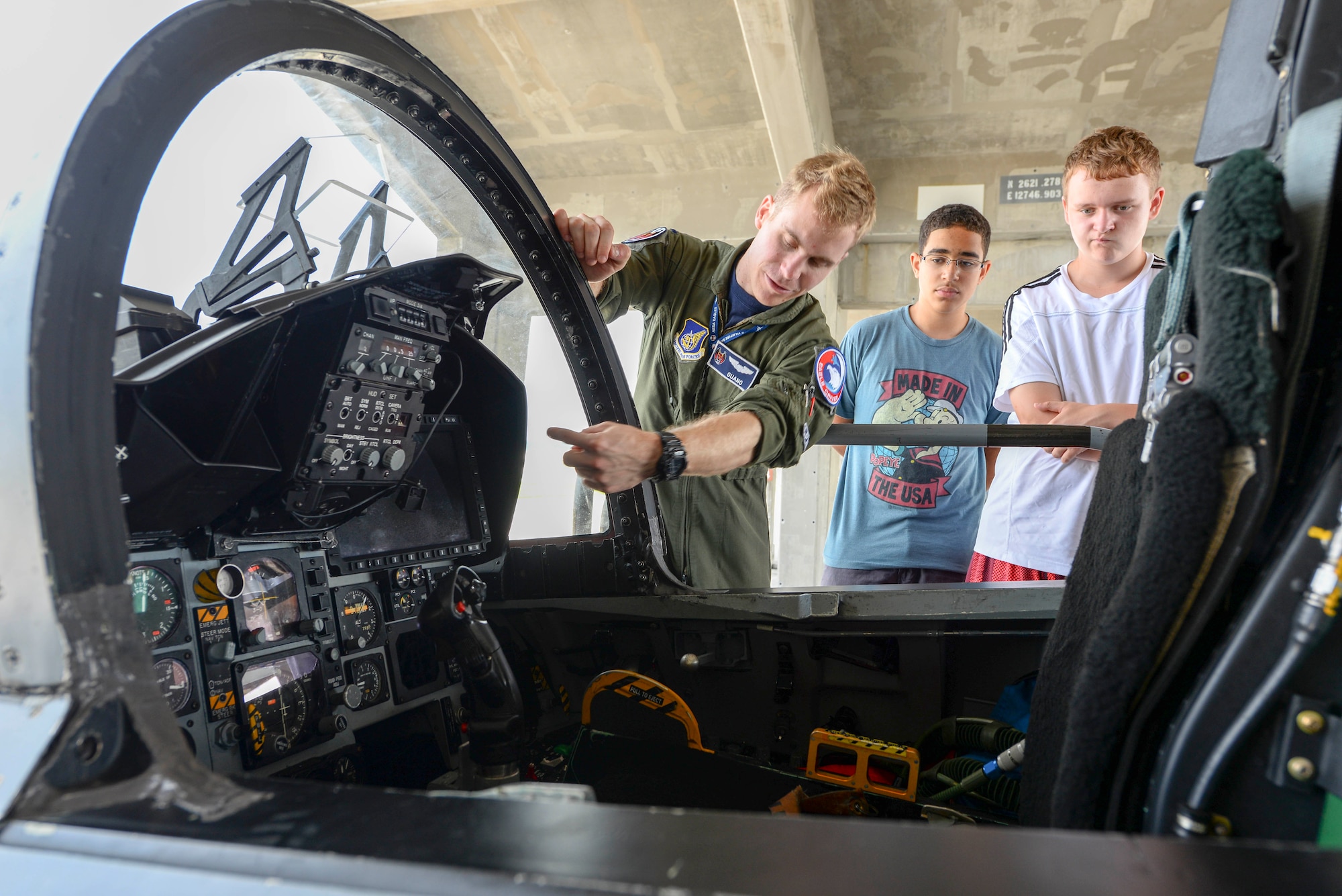 1st Lt. Austin Curley, 44th Fighter Squadron pilot, shows Kadena Middle School students, Zack Nees and Kameron Ferrin, the cockpit of an F-15 Eagle during a STEM-oriented field trip April 22, 2016, at Kadena Air Base, Japan. The students were given a comprehensive tour and learned about how Science, Technology, Engineering and Math research is foundational to both modern and future warfare. (U.S. Air Force photo by Senior Airman John Linzmeier) 