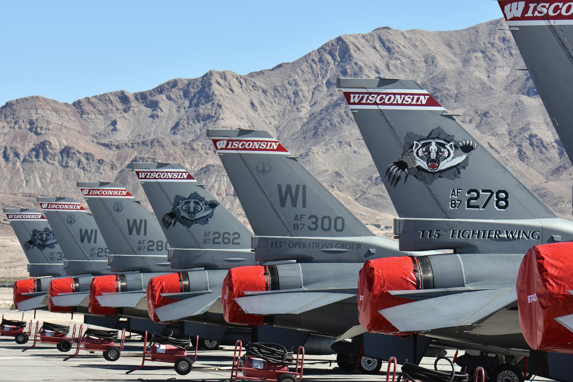 The distinctive tail markings of F-16 Fighting Falcons from the 115th Fighter Wing in Madison, Wis., adorn the aircraft ramp at Nellis Air Force Base, Nev., April 2, 2016. The Wisconsin Air National Guard unit deployed more than 100 Airmen and eight F-16 Fighting Falcons for two weeks to support advanced training in weapons and tactics employment at the United States Air Force Weapons School. (U.S. Air National Guard photo by Master Sgt. Paul Gorman/Released)