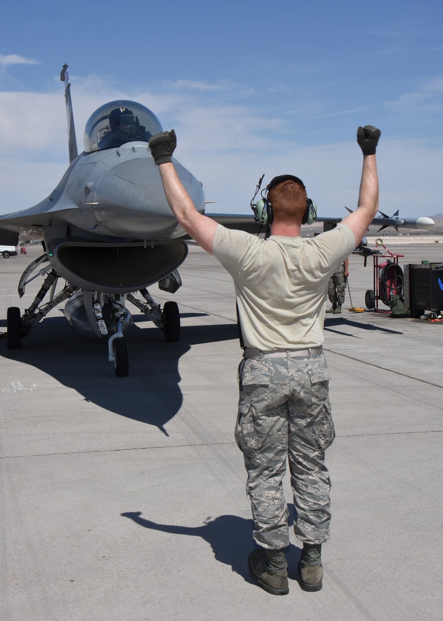 Airman 1st Class Nathan Moll, aircraft maintenance specialist with the 115th Fighter Wing in Madison, Wis., marshals an F-16 Fighting Falcon on the aircraft ramp at Nellis Air Force Base, Nev., April 4, 2016. The Wisconsin Air National Guard unit deployed more than 100 Airmen and eight F-16 Fighting Falcons for two weeks to support advanced training in weapons and tactics employment at the United States Air Force Weapons School. (U.S. Air National Guard photo by Master Sgt. Paul Gorman/Released)