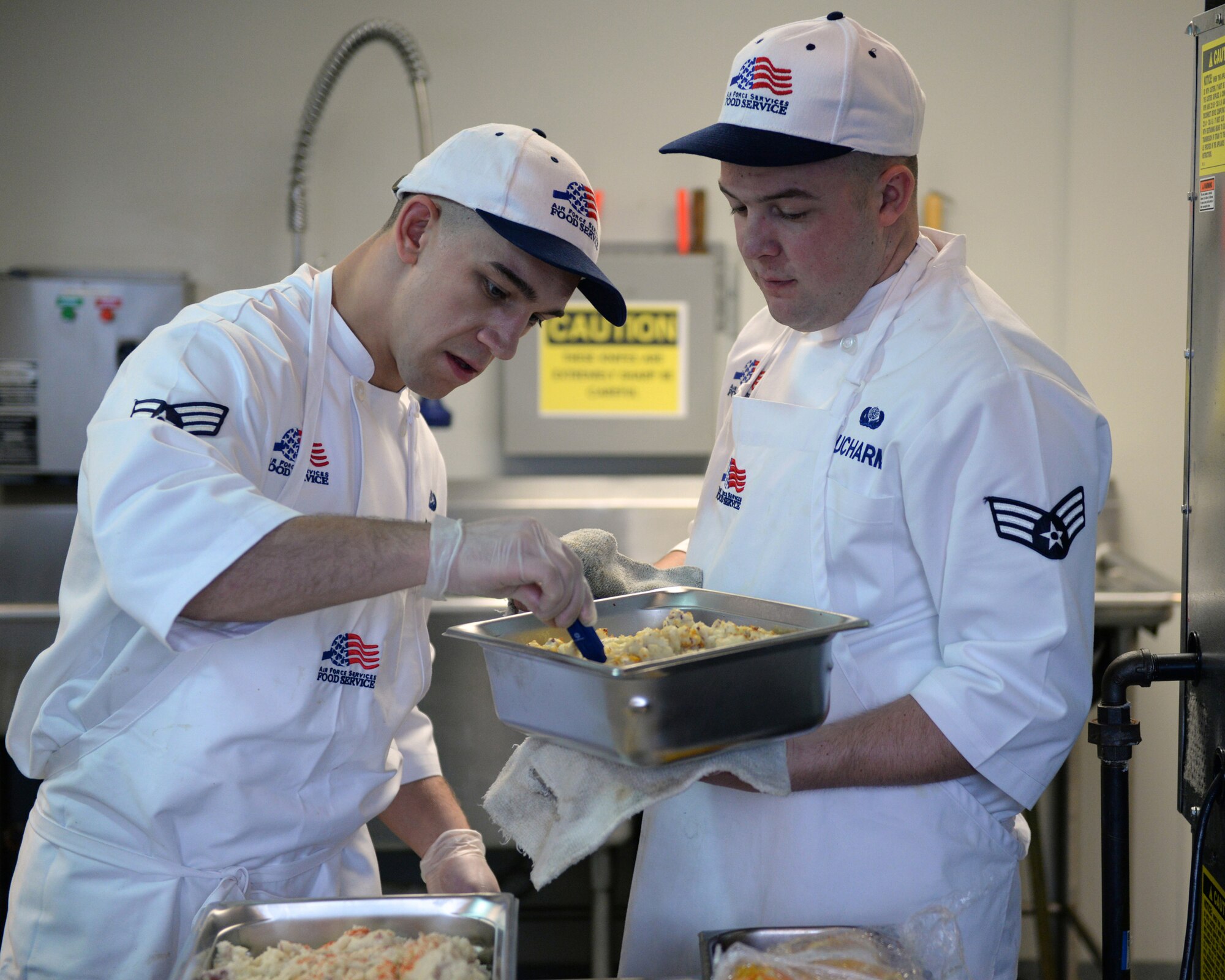 Senior Airman Caleb D. Cejka and Senior Airman Ryan A. Ducharme of the 157th Force Support Squadron’s Sustainment Services Flight prepare food during the unit training assembly, April 2, 2016. (U.S. Air National Guard photo by Staff Sgt. Curtis J. Lenz) 