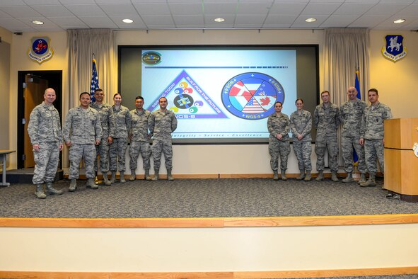 Col. Dennis Bythewood (left), 50th Operations Group commander, and Lt. Col. Chris Todd (second from left), 3rd Space Operations Squadron commander, present the eight Airmen selected to be part of the Launch and Early Orbit Teams for Wideband Global SATCOM-8 and 9 during a ceremony at Schriever Air Force Base, Colorado, Thursday, April 21, 2016. The Airmen endured a competitive selection process, which includes knowledge-based tests, problem solving scenarios and interviews. (U.S. Air Force photo/Christopher DeWitt)