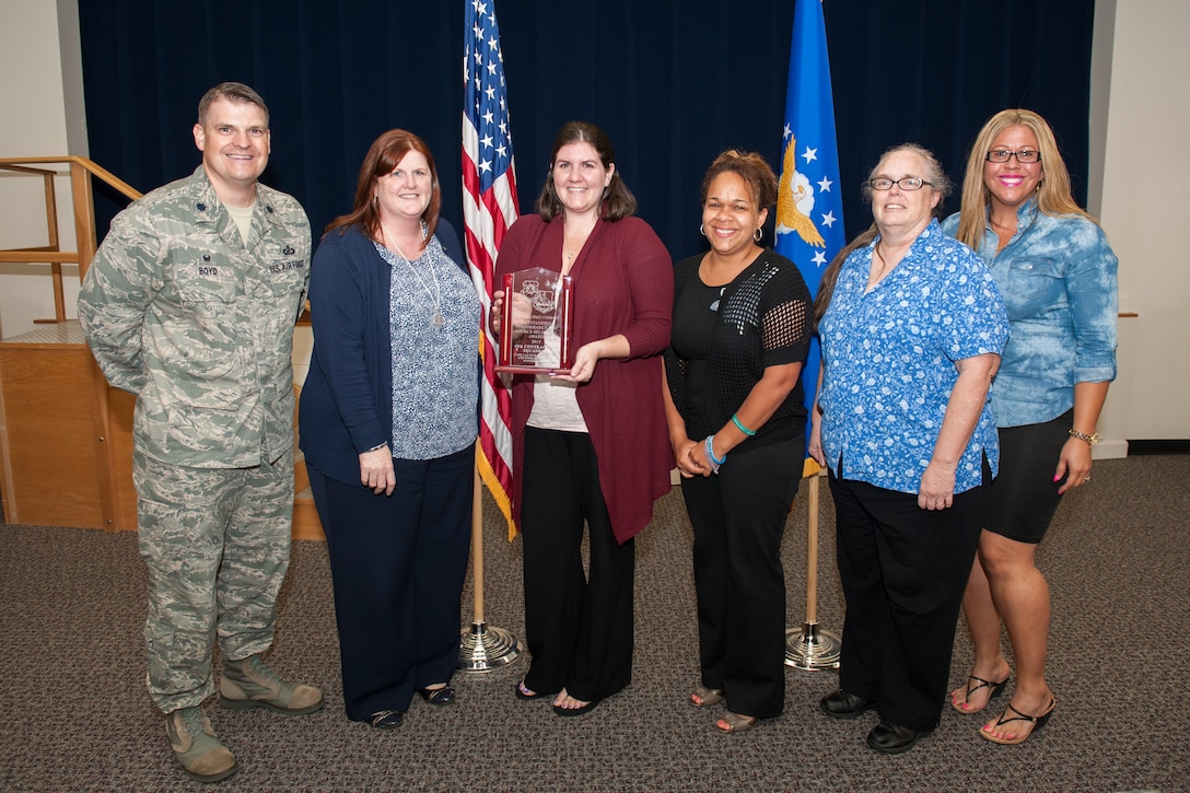 Lt. Col. Aaron Boyd, 45th Contracting Squadron commander, poses with the Cape Launch Operations and Infrastructure Support Source Selection Team after presenting them with the 2015 Air Force Space Command award for Outstanding Performance in a source selection March 29 during the squadron’s Commander’s Call at Patrick Air Force Base, Florida. (U.S. Air Force photo by Benjamin Thacker/Released)