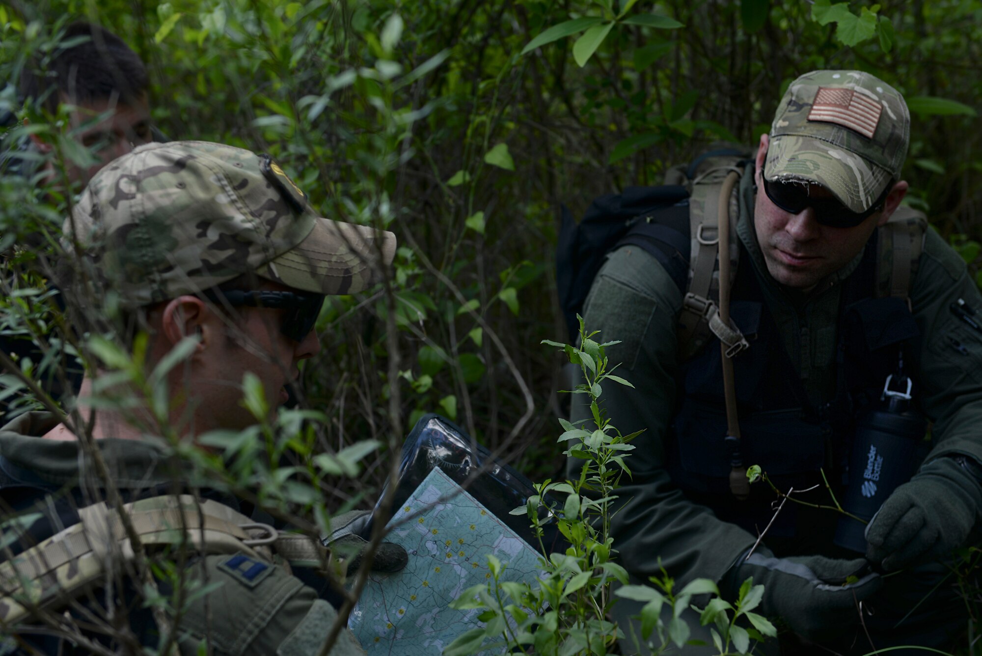 From left, U.S. Air Force Capt. Jon Clausen, 61st Airlift Squadron C-130J pilot, and U.S. Air Force Staff Sgt. Matthew Morgridge, 61st Airlift Squadron C-130J loadmaster, review a topographic map April 22, 2016, near Ft. Polk, La. Clausen and Morgridge, along with other aircrew members, used various methods without any radio transmission to be recovered during Green Flag 16-06. (U.S. Air Force photo by Airman 1st Class Mercedes Taylor) 