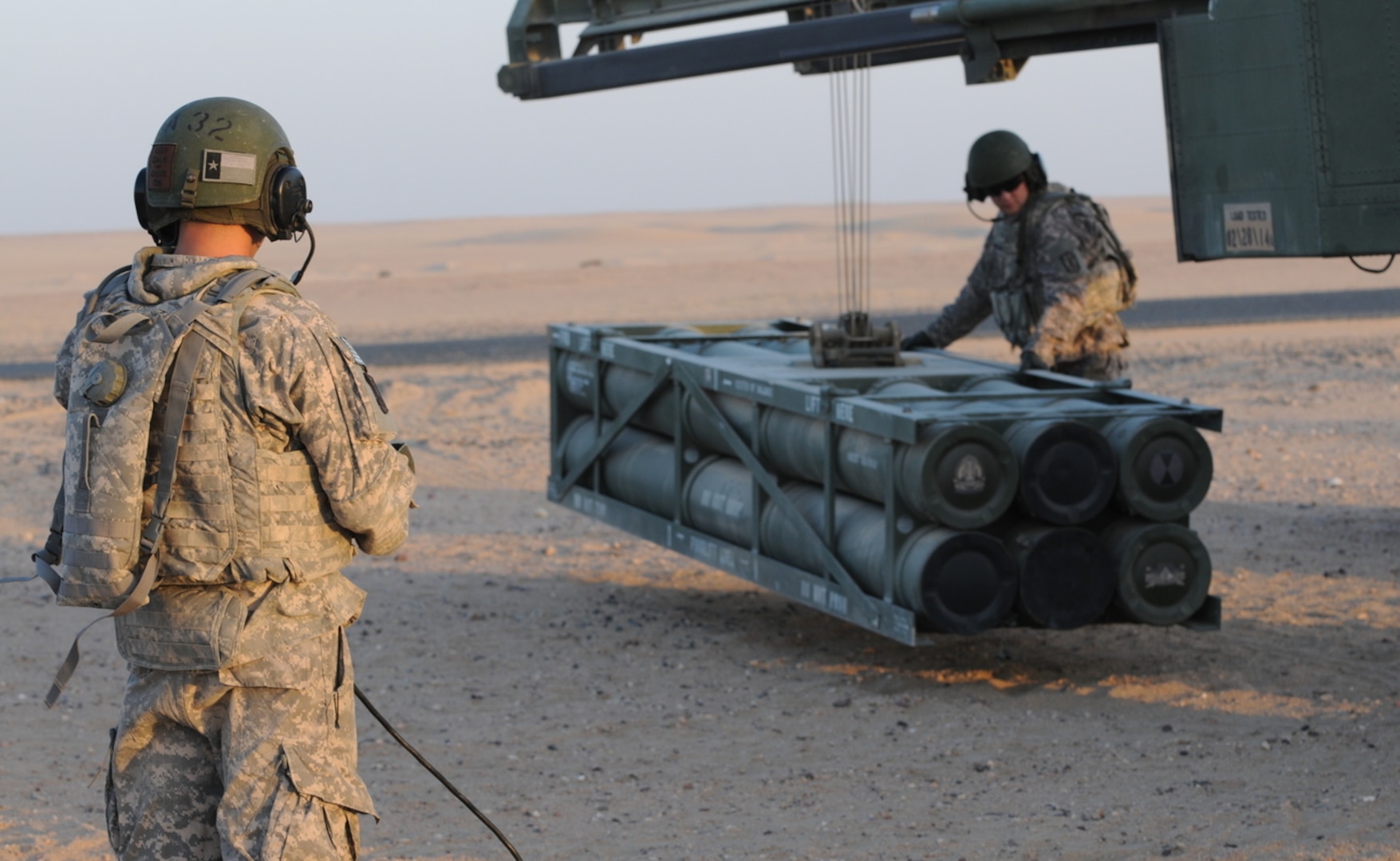 Staff Sgt. Jonathon Hoffnauer, High Mobility Artillery Rocket System (HiMARS) Crew Chief, and Spc. Mario Ybarra, HiMARS Gunner, load a rocket pod onto a M142 High Mobility Artillery Rocket System (HiMARS).  (U.S. Army photo by Staff Sgt. Noel Gerig)