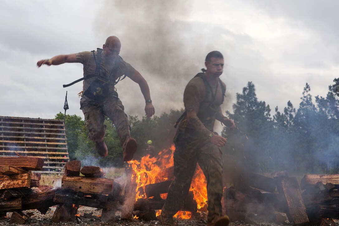 Army Rangers jump over smoldering logs at the Spartan event during Best Ranger Competition 2016 at Fort Benning, Ga., April 16, 2016. Army photo by Spc. Tracy McKithern