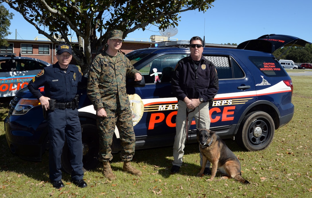 Staff Sgt. Paul Delekto (center), services chief, Marine Corps Police Department, Marine Corps Logistics Base Albany, poses with “Flat Stanley” during a recent photo shoot. Flat Stanley experienced what it was like to be a military police officer aboard a Marine Corps installation.