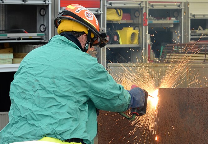 A member of the Georgia Search and Rescue Team Task Force II cuts through a piece of steel plate at a simulated collapsed structure during Exercise Black Swan 2016, here, April 12.