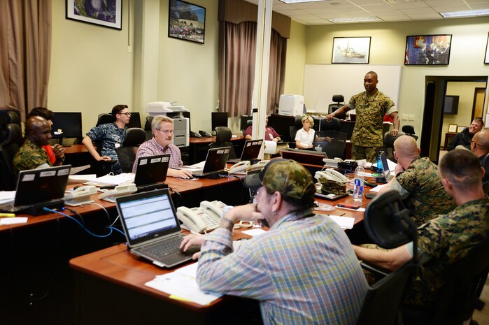 Marine Corps Logistics Base Albany staff members debrief the senior watch officer during Exercise Black Swan 2016, here, April 13.