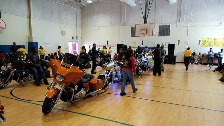 Several Marine Corps Logistics Base Albany civilian-Marines as well as contractors join more than a dozen area bikers from several motorcycle clubs and organizations at West Town Elementary School, Albany, Georgia, for a pep rally, recently. Principal Steven Dudley and other school personnel invited motorcyclists to the event to entertain, educate and motivate students. The roughly 20 bikers suited up in their traditional riders gear to participate in the celebration, which was organized to reward the students for their success in raising their reading scores by more100 points.