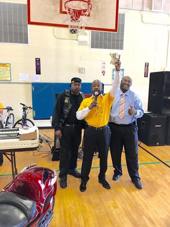 Several Marine Corps Logistics Base Albany civilian-Marines as well as contractors join more than a dozen area bikers from several motorcycle clubs and organizations at West Town Elementary School, Albany, Georgia, for a pep rally, recently. Principal Steven Dudley (center) and other school personnel invited motorcyclists to the event to entertain, educate and motivate students. The roughly 20 bikers suited up in their traditional riders gear to participate in the celebration, which was organized to reward the students for their success in raising their reading scores by more100 points.