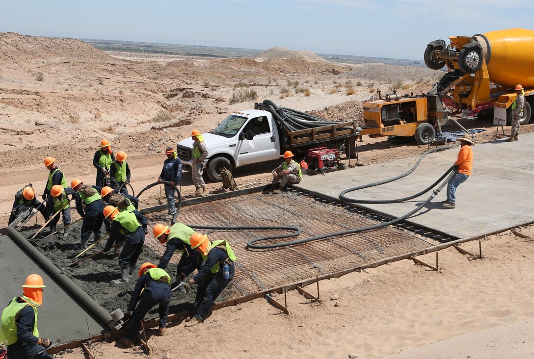 U.S. Marines with 7th Engineer Support Battalion assist in pouring out concrete during a road improvement project with Joint Task Force North in El Centro, California, April 19, 2016. For the last two months, the Marines have been processing and leveling dirt to improve the road’s quality as well as constructing low-water crossings to maintain the integrity of the road during wet conditions. 