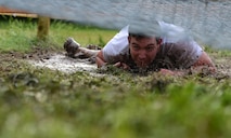 A competitor at the 12th Annual Adventure Race low crawls through an obstacle on Laughlin Air Force Base, Texas, April 23, 2016. The run portion of the race included mystery challenges along the route. (U.S. Air Force photo by Senior Airman Ariel D. Partlow)