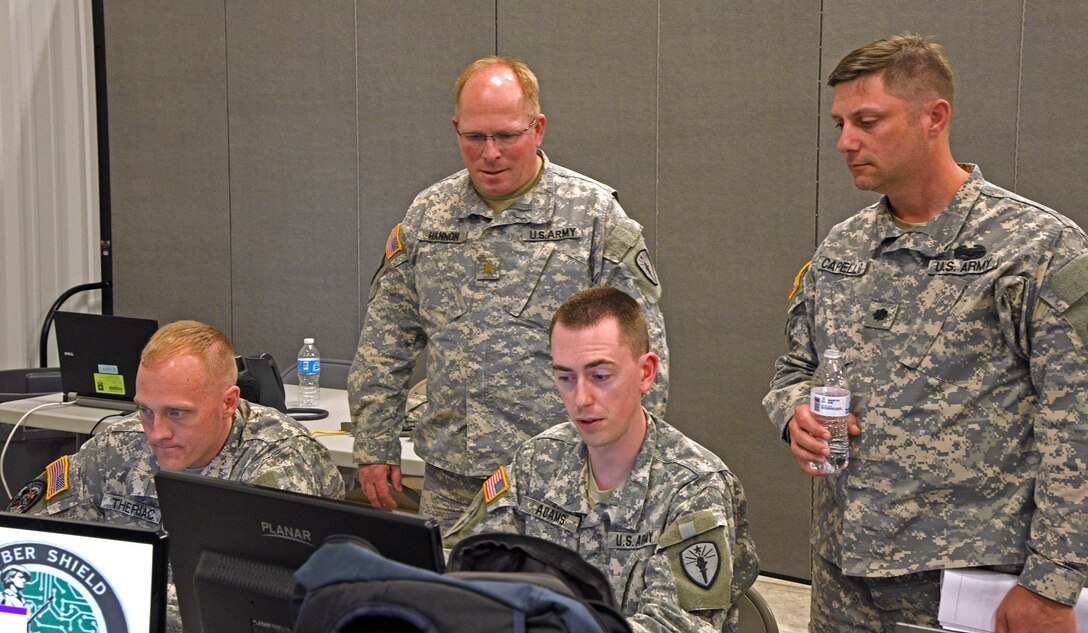 The Indiana National Guard Computer Network Defense Team (L-R: Staff Sgt. Jonathan Theriac, CW2 Joshua Adams, Cyber Team Commander Maj. Michael Hannon) meets with Lt. Col. Henry Capello, the exercise director for Cyber Shield 2016 in order to check connectivity prior to the start of the exercise at Camp Atterbury, Ind., on Wednesday, April 20. (Indiana National Guard photo by Master Sgt. Brad Staggs, Atterbury-Muscatatuck Public Affairs)