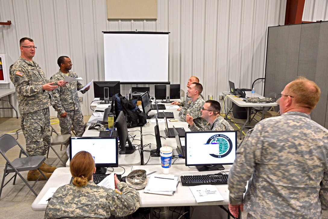 The Indiana National Guard Computer Network Defense Team (L-R: Staff Sgt. Richard Dillon, Staff Sgt. Anthony Hill, Staff Sgt. Haley Brown, Maj. Michael Hannon, Sgt. Charles Powell, CW2 Joshua Adams, Staff Sgt. Jonathan Theriac) readies their workstations for the Cyber Shield 2016 exercise going on at Camp Atterbury, Ind., on Wednesday, April 20. (Indiana National Guard photo by Master Sgt. Brad Staggs, Atterbury-Muscatatuck Public Affairs)