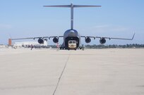 A C-17 Globemaster III lands at Joint Forces Training Base Los Alamitos, Calif., while ground crew conducts a "cold offload" of a Light Medium Tactical Vehicle during  Operation Patriot Hook, April 23, 2016. Operation Patriot Hook is a joint service and inter-agency exercise which partners local military branches with members of local, federal, and state agencies to practice their combined response procedures in case of major regional disasters such as earth quakes, riots, or fires. In its 29th year as an
exercise, agencies involved in this year's Operation Patriot Hook included the U.S. Army Reserve, the U.S. Air Force Reserve, the Department of Homeland Security, and the FBI. (U.S. Army Photo by Sgt. 1st Class Alexandra Hays, 201st Press Camp Headquarters).