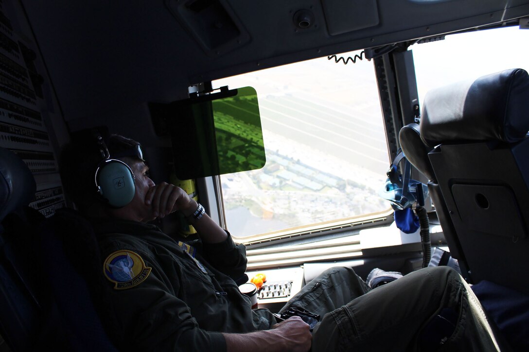 Air Force Reserve Maj. Nathan Childers with the 729th Airlift Squadron out of March Joint Air Reserve Base, Calif., looks out the window during a C-17 Globemaster III flight from Joint Forces Training Base Los Alamitos to Naval Air Station North Island, Calif., during  Operation Patriot Hook, April 23, 2016. Operation Patriot Hook is a joint service and inter-agency exercise which partners local military branches with members of local, federal, and state agencies to practice their combined response procedures in case of major regional disasters such as earth quakes, riots, or fires. In its 29th year as an exercise, agencies involved in this year's Operation Patriot Hook included the U.S. Army Reserve, the U.S. Air Force Reserve, the Department of Homeland Security, and the FBI. (U.S. Army Photo by Pfc. Nicholle D. Salvatierra, 222nd Broadcast Operations Detachment).