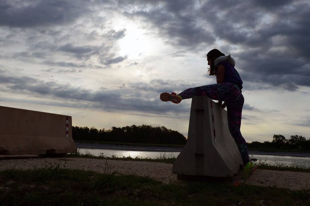 A competitor steps over a concrete barrier during Adventure Race XII at Laughlin Air Force Base, Texas, April 23, 2016. While participating in the run portion of the race, competitors participated in mystery challenges to include barrier hurdles, six-foot walls and a low-crawl. (U.S. Air Force photo by Senior Airman Jimmie D. Pike)