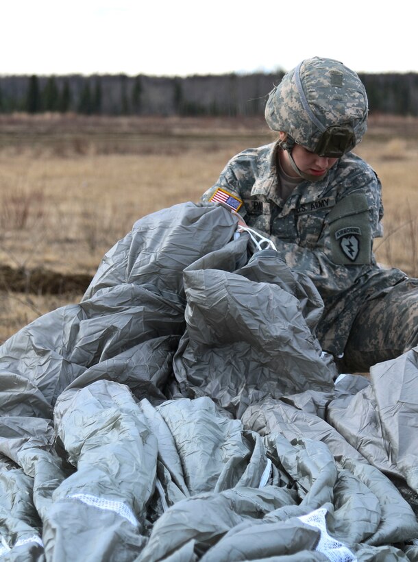 Army Pfc. Keiley Parker recovers her T-11 parachute after participating in an airborne operation onto Malemute drop zone at Joint Base Elmendorf-Richardson, Alaska, April 14, 2016. Army photo by Staff Sgt. Brian K. Ragin Jr.