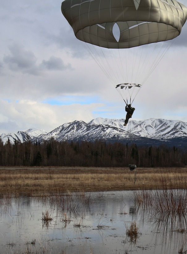 A paratrooper prepares to land in the water at Malemute drop zone at Joint Base Elmendorf-Richardson, Alaska, April 14, 2016. Alaska. Army photo by Staff Sgt. Brian K. Ragin Jr.