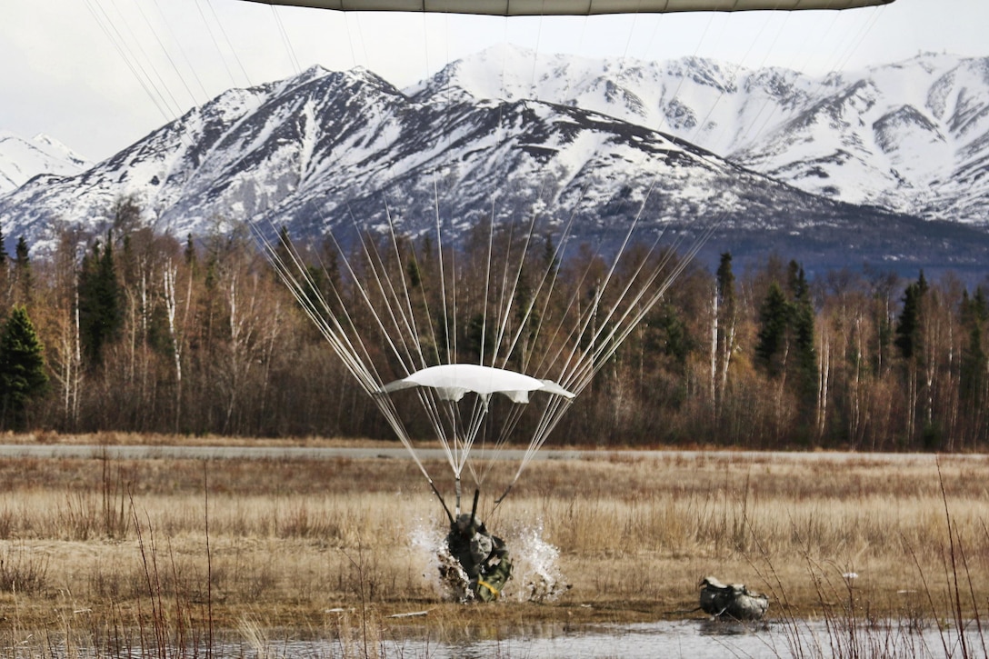 A paratrooper performs a parachute landing fall into water at Malemute drop zone at Joint Base Elmendorf-Richardson, Alaska, April 14, 2016. Army photo by Staff Sgt. Brian K. Ragin Jr.