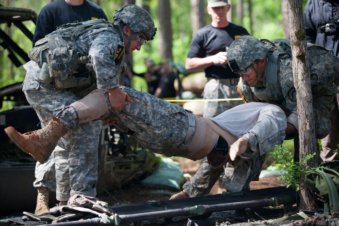 Army Sgt. 1st Class Eugene Mirador, right, and Army Cpl. Scott Slater move a simulated casualty onto a litter during the Best Ranger Competition at Fort Benning, Ga., April 16, 2016. Mirador and Slater are assigned to the 75th Ranger Regiment. Army photo by Sgt. Austin Berner