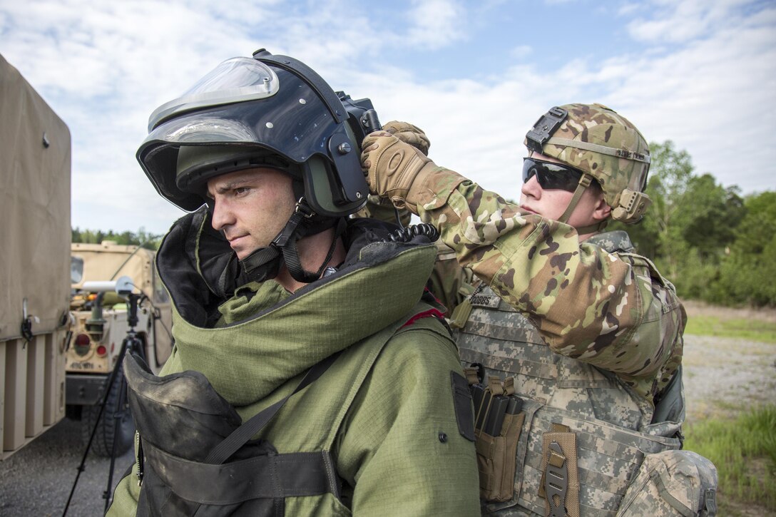 Army Cpl. Drew Dobbs, right, helps Staff Sgt. Denver Colin attach his protective helmet for an explosive device exercise during the Ordnance Group Team of the Year 2016 competition at the Wendell H. Ford Regional Training Center in Greenville, Ky., April 26, 2016. The competition selects the most physically, mentally, tactically and technically fit team to participate in future competition. Army photo by Staff Sgt. Brian Kohl