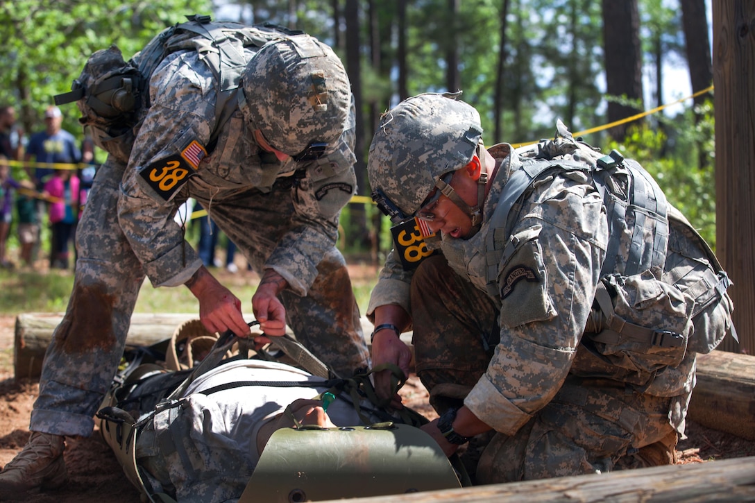 Army Sgt. 1st Class Eugene Mirador, right, and Army Cpl. Scott Slater strap in a simulated casualty on a Skedco litter during the Best Ranger Competition at Fort Benning, Ga., April 16, 2016. Mirador and Slater are assigned to the 75th Ranger Regiment. Army photo by Sgt. Austin Berner