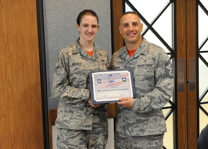 Senior Master Sgt. John Carbon (right), Air Force Personnel Center first sergeant, presents the Dorm of the Quarter award to Airman 1st Class Bailey Wagner, AFPC retirement section technician, for keeping her living quarters in tip-top shape. The First Sergeants Council's primary purpose is to advise and assist command in making decisions necessary to improve and promote the quality of life for Joint Base San Antonio-Randolph personnel.  
Photo by Melissa Peterson
