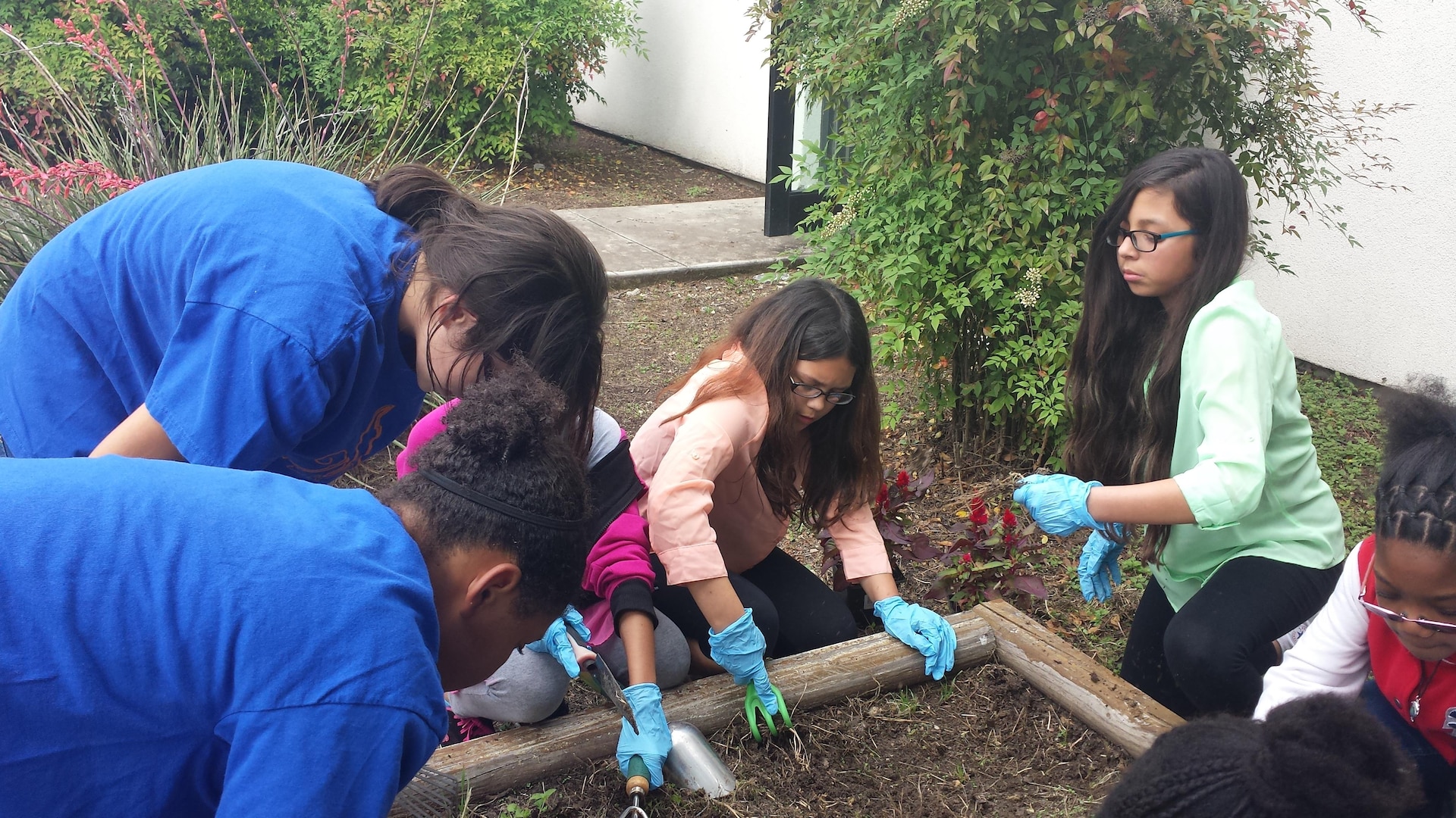 Members of the Joint Base San Antonio-Randolph Youth Programs' Torch Club plant flowers on the Youth Programs grounds April 19 for their Earth Day project.