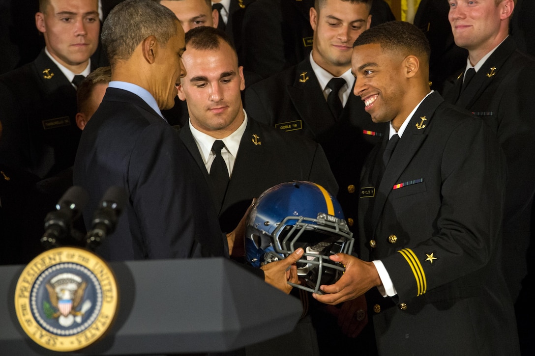 U.S. Naval Academy football team co-captain and college record-breaking quarterback Keenan Reynolds presents President Barack Obama with a team helmet during a Commander in Chief’s Trophy award ceremony at the White House in Washington, D.C., April 27, 2016. The president presents the trophy to the Defense Department team with the most victories against its service rivals. DoD photo by EJ Hersom