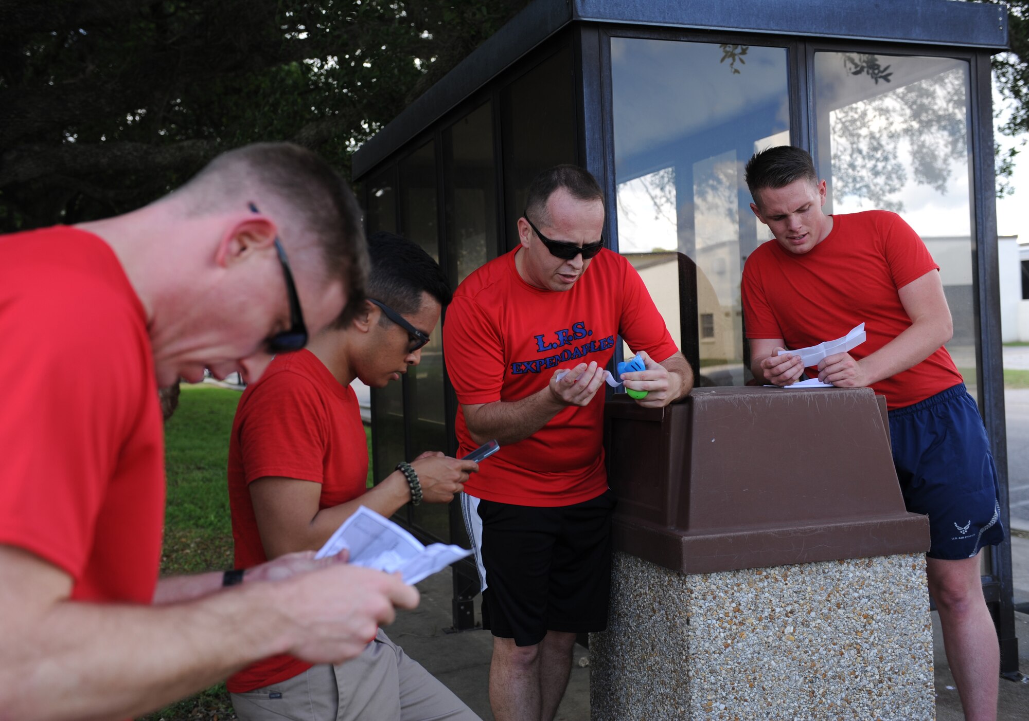 “L.R.S. Expendables” team members work together to figure out a clue near Cody Hall during the Wingman Week Heritage Hunt April 26, 2016, Keesler Air Force Base, Miss. The hunt, consisting of eight teams, was one of many events held throughout the week. The “Training Group-A” team was the winner of the event. (U.S. Air Force photo by Kemberly Groue)