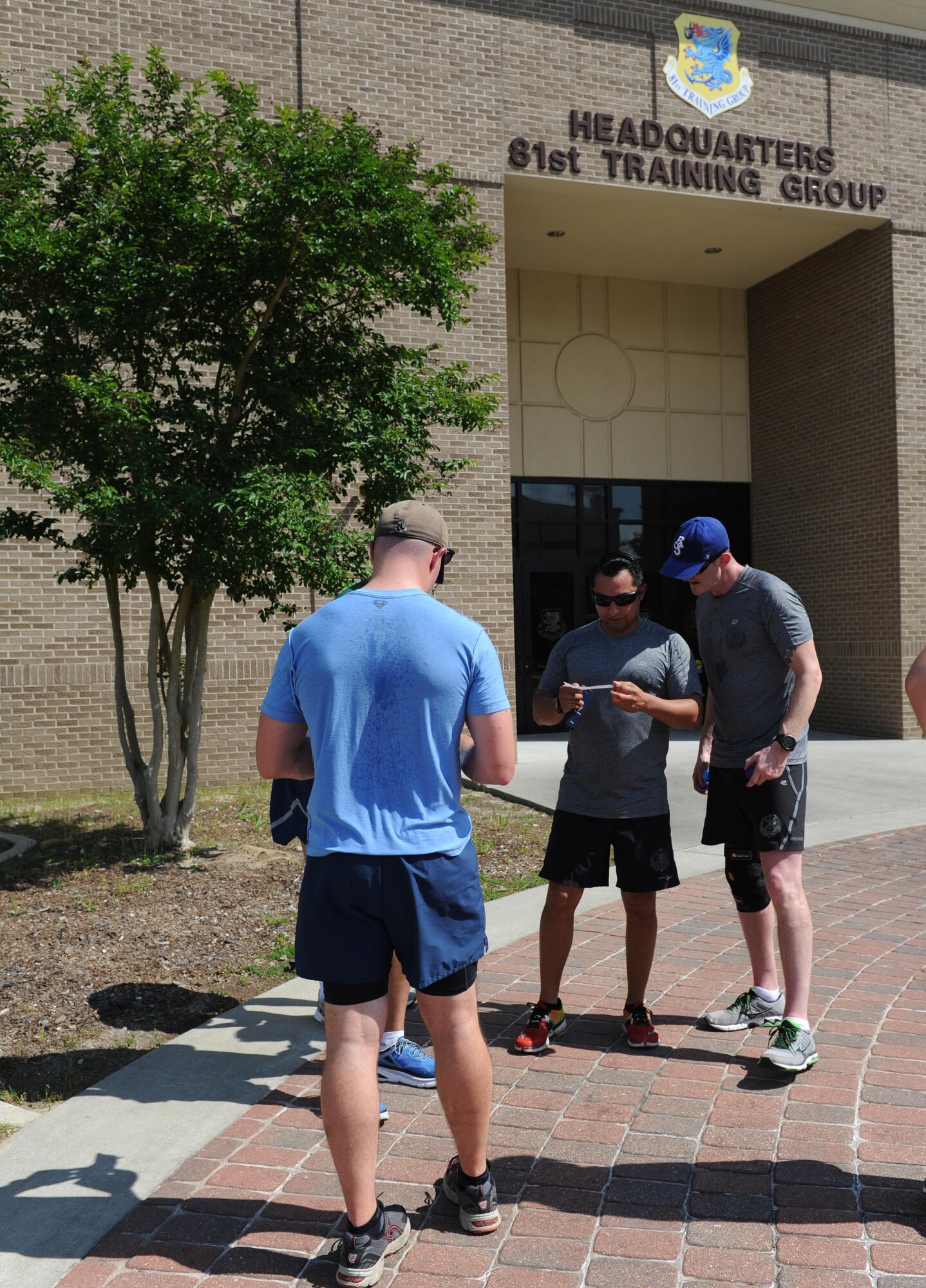 “GatorBulls” team members work together to figure out a clue in front Matero Hall during the Wingman Week Heritage Hunt April 26, 2016, Keesler Air Force Base, Miss. The hunt, consisting of eight teams, was one of many events held throughout the week. The “Training Group-A” team was the winner of the event. (U.S. Air Force photo by Kemberly Groue)