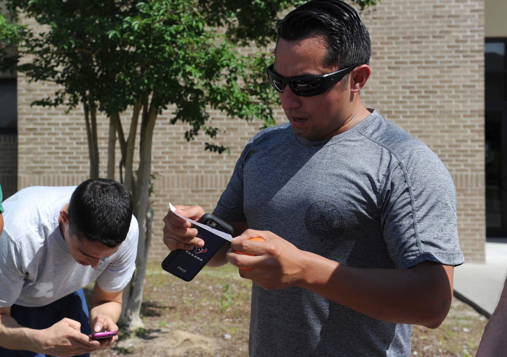 “GatorBulls” team member, Staff Sgt. Joey, 335th Training Squadron special operations weather instructor, reads a clue to his teammates in front Matero Hall during the Wingman Week Heritage Hunt April 26, 2016, Keesler Air Force Base, Miss. The hunt, consisting of eight teams, was one of many events held throughout the week. The “Training Group-A” team was the winner of the event. (U.S. Air Force photo by Kemberly Groue)