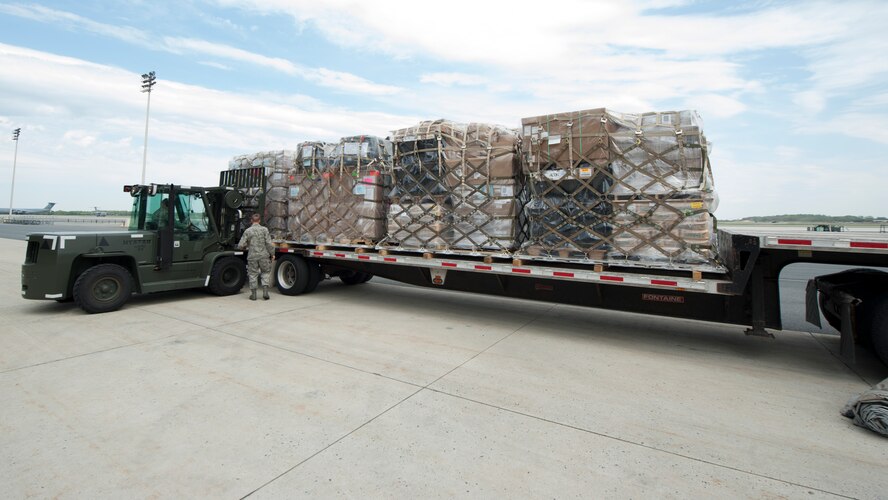 Palletized cargo is loaded onto a flatbed truck by Senior Airman Brandon Haney and Staff Sgt. Damon Huddleston, both 436th Aerial Port Squadron traffic management, April 26, 2016, at the Aerial Port on Dover Air Force Base, Del. Thus far, enough cargo has been transported to Joint Base McGuire-Dix-Lakehurst, N.J. to fill 13 747 cargo planes. (U.S. Air Force photo/Senior Airman Zachary Cacicia)