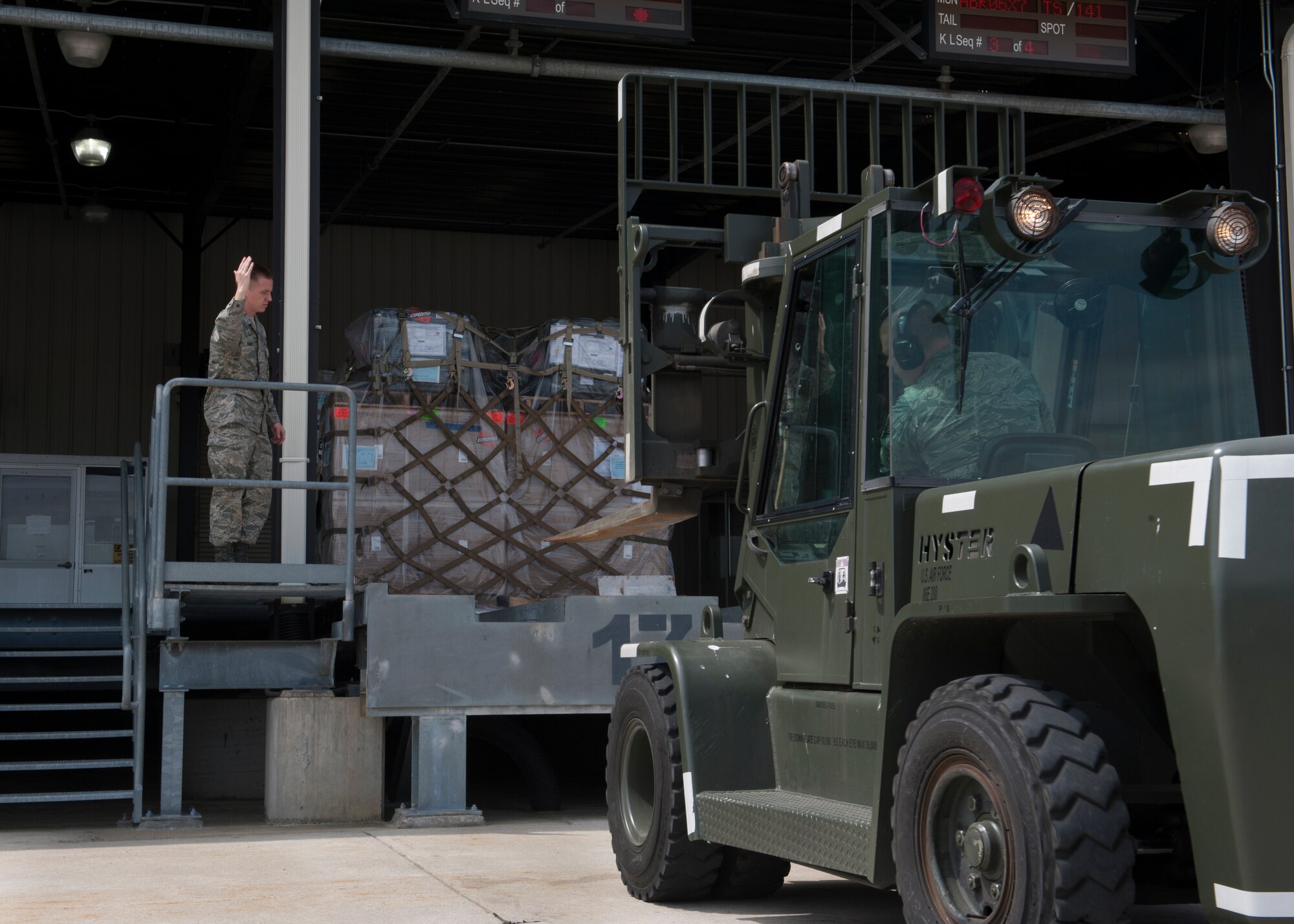 Senior Airman Brandon Haney, 436th Aerial Port Squadron traffic management, directs a forklift driven by Staff Sgt. Damon Huddleston, 436th APS traffic management, April 26, 2016, at the Aerial Port on Dover Air Force Base, Del. During Dover AFB’s shortened runway operations due to ongoing runway construction, any cargo amount that exceeds the capabilities of Dover’s C-17A Globemaster III fleet will be transported to Joint Base McGuire-Dix-Lakehurst, N.J. (U.S. Air Force photo/Senior Airman Zachary Cacicia)