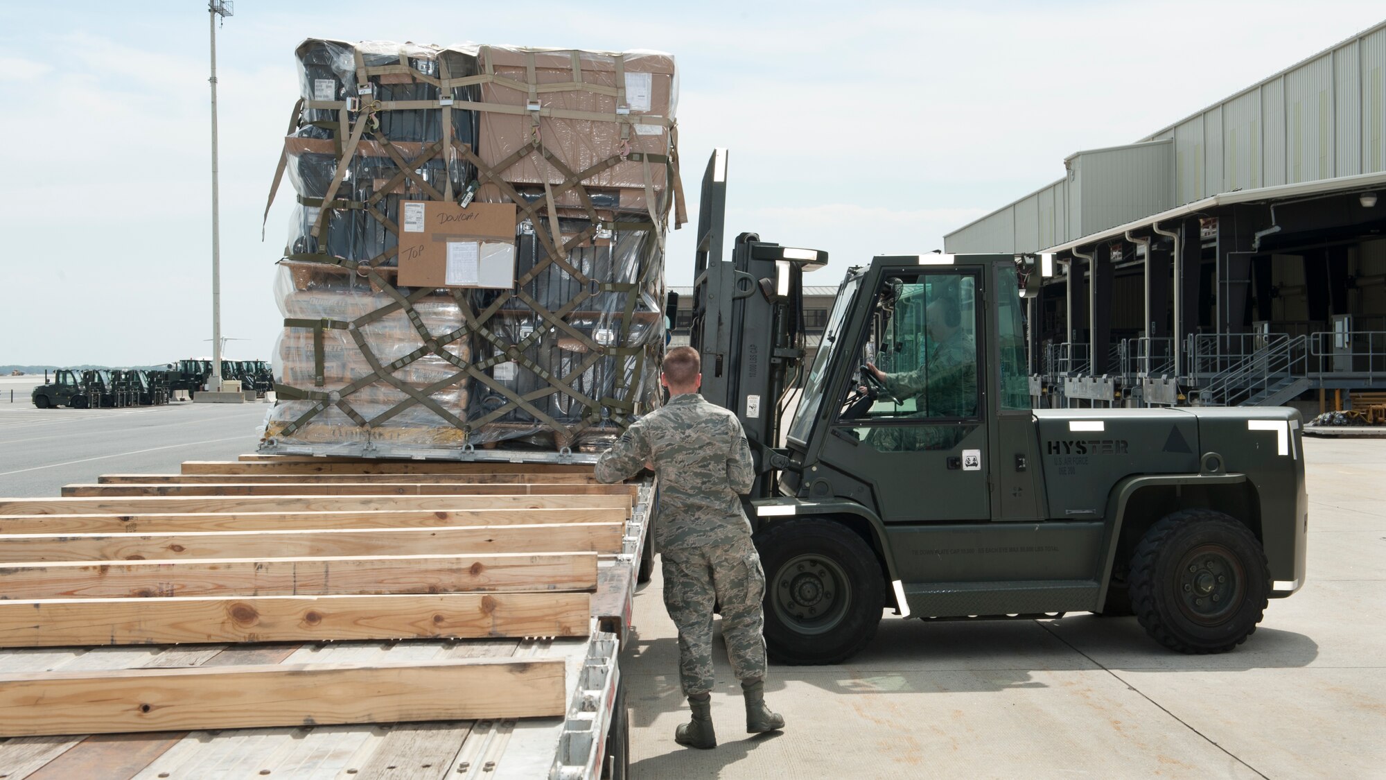 Senior Airman Brandon Haney, 436th Aerial Port Squadron traffic management, spots a forklift driven by Staff Sgt. Damon Huddleston, 436th APS traffic management, as he places a cargo pallet onto a flatbed truck April 26, 2016, at the Aerial Port on Dover Air Force Base, Del. All cargo that transits Dover AFB is processed through the Aerial Port. (U.S. Air Force photo/Senior Airman Zachary Cacicia)