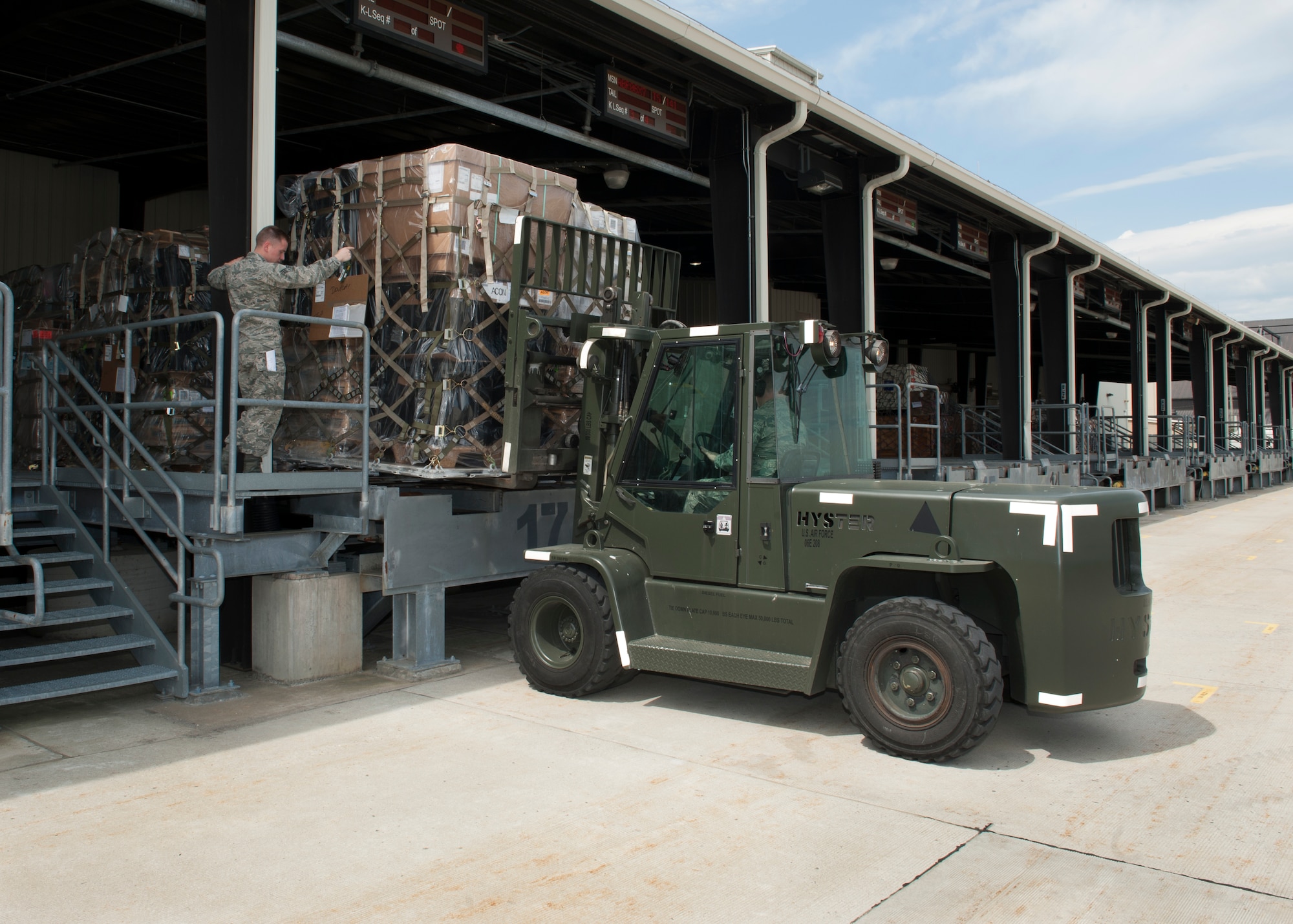 Senior Airman Brandon Haney, 436th Aerial Port Squadron traffic management, directs a forklift driven by Staff Sgt. Damon Huddleston, 436th APS traffic management, as it lifts a cargo pallet April 26, 2016, at the Aerial Port on Dover Air Force Base, Del. Since the start of shortened runway operations at Dover AFB in March 2016, the Aerial Port has shipped 900 tons of cargo to Joint Base McGuire-Dix-Lakehurst, N.J. (U.S. Air Force photo/Senior Airman Zachary Cacicia)