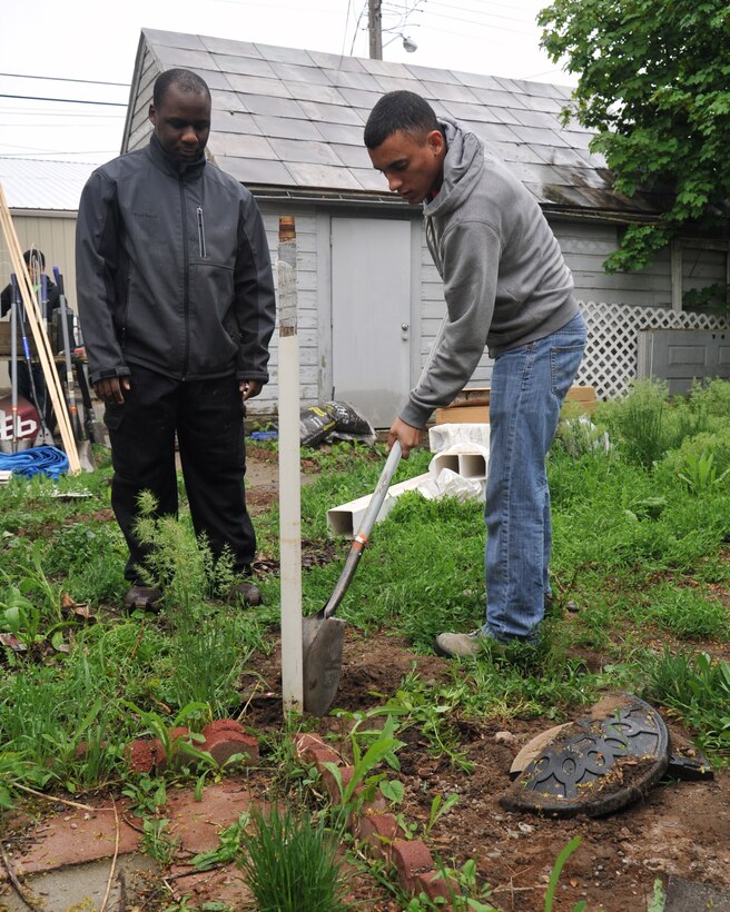 Senior Airman Davante Presley and Senior Airmen Jonathan Rivera, both 93rd Air Refueling Squadron aviation resource managers, remove a post and level the ground during a volunteer event April 23, 2016, in Spokane, Wash. Members of the 93rd ARS helped a local family in need by removing an old roof and installing a new one, leveled the back yard to lay sod and trimmed plants around the house. (U.S. Air Force photo/Staff Sgt. Samantha Krolikowski) 