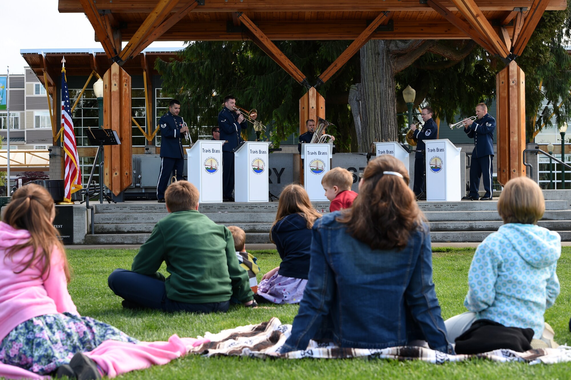 A family listens to the U.S. Air Force Band of the Golden West Travis Brass at Pioneer Park in Puyallup, Wash., April 24, 2016. The Travis Brass is a part of the U.S. Air Force Band of the Golden West stationed at Travis Air Force Base, Calif., and serves to tell the Air Force Story around the world by performing for diverse audiences. (U.S. Air Force photo/Staff Sgt. Naomi Shipley)
