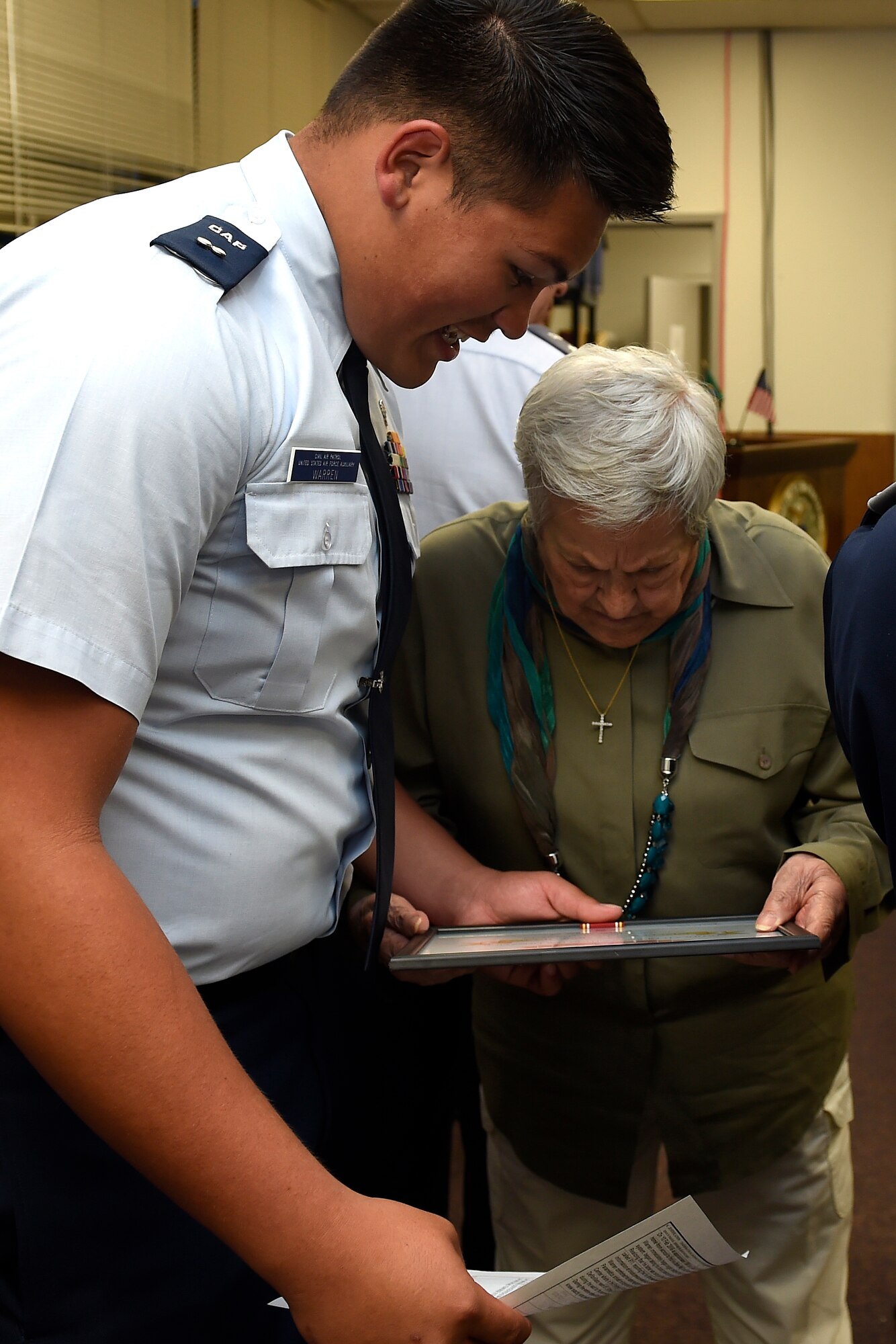 Civil Air Patrol Cadet 1st Lieutenant Max Warren II (left) shows his grandmother Lorraine Warren his CAP Certificate of Recognition for Lifesaving he received on April 26, 2016, at Joint Base Lewis-McChord, Wash. Warren provided crucial lifesaving actions to his father Donald Warren Feb. 10, 2016 while his father was experiencing a heart attack. Max provided his father with oxygen, monitored his vitals and kept him calm while contacting emergency personnel. (U.S Air Force photo/Tech. Sgt. Tim Chacon)