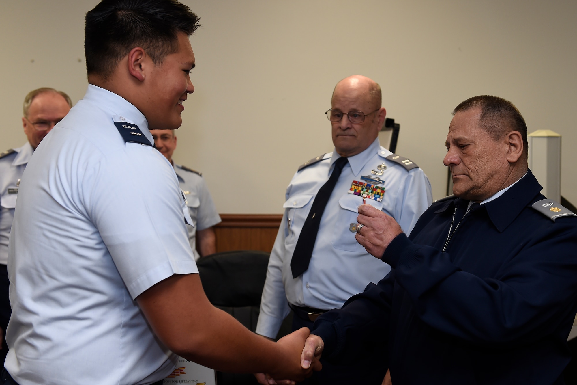 Civil Air Patrol Cadet 1st Lieutenant Max Warren II (left) receives the CAP Certificate of Recognition for Lifesaving from his father Civil Air Patrol Maj. Donald Warren April 26, 2016 at Joint Base Lewis-McChord, Wash. Donald Warren experienced a heart attack Feb. 10, 2016 and credits his son Max and his immediate and level headed thinking to keeping him alive until paramedics arrived. (U.S Air Force photo/Tech. Sgt. Tim Chacon)
