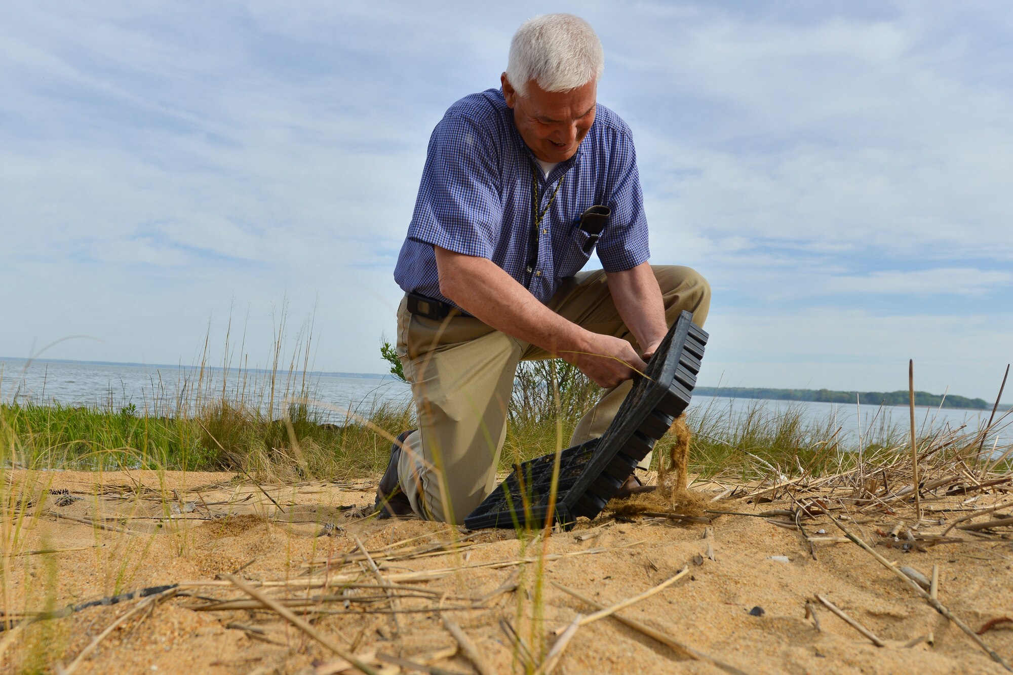 Terry Sanders, natural resources contractor assigned to the 733rd Civil Engineer Division, plants marsh grass during an Earth Week activity at Fort Eustis, Va., April 19, 2016.   Joint Base Langley-Eustis held several preservation and educational events throughout the week to promote continuous environmental stewardship. (U.S. Air Force photo by Staff Sgt. Natasha Stannard)