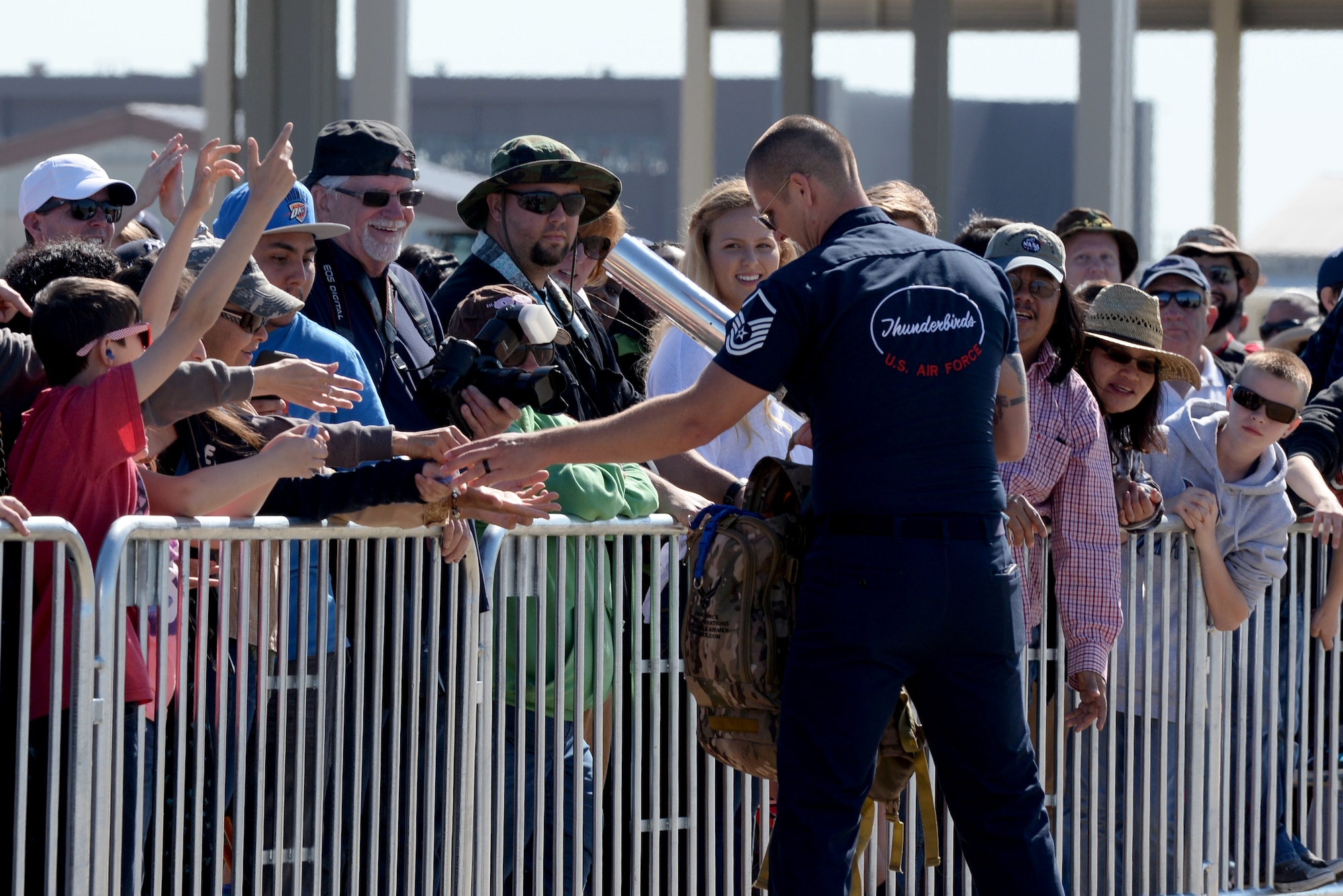 A U.S. Air Force Thunderbirds aerial demonstration team member passes out memorabilia during the AirPower over Hampton Roads Open House at Langley Air Force Base, Va., April 24, 2016. The Thunderbirds headlined the open house and performed precision aerial maneuvers, demonstrating the capabilities of high performance aircraft to the Hampton Roads community. (U.S. Air Force photo by Airman 1st Class Kaylee Dubois)
