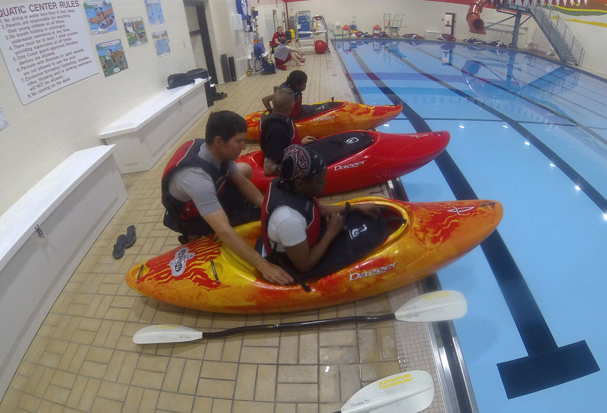 Karl Lavtar, Outdoor Recreation Center kayaking class lead, helps Jacoba Merschoff put on her spray skirt at the Joint Base Elmendorf-Richardson Elmendorf Fitness Center pool, April 15, 2016. A kayak spray skirt is used to keep the inside of the kayak water-free so it always floats. Army Staff Sgt. Timothy Merschoff, F Company, 2nd Battalion 377th Parachute Field Artillery Regiment, 4th Infantry Brigade Combat Team (Airborne), 25th Infantry Division, brought his wife, Jacoba, and daughter, Kiley, to learn how to roll in a kayak for their upcoming summer trips. (U.S. Air Force photo by Airman 1st Class Christopher R. Morales)