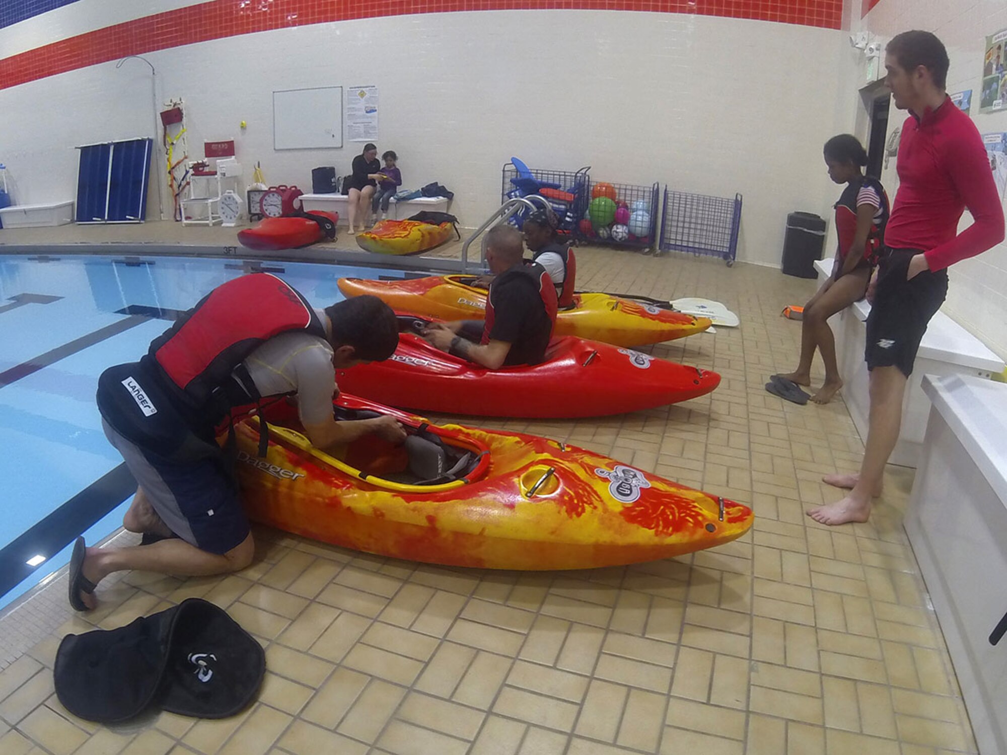 Karl Lavtar, Outdoor Recreation Center kayaking class lead, adjusts the kayak seat for a student at the Joint Base Elmendorf-Richardson Elmendorf Fitness Center pool, April 15, 2016. The kayak rolling class teaches participants how to roll the kayak over while in the water in case something tips them over and there is no need to exit the kayak. (U.S. Air Force photo by Airman 1st Class Christopher R. Morales)